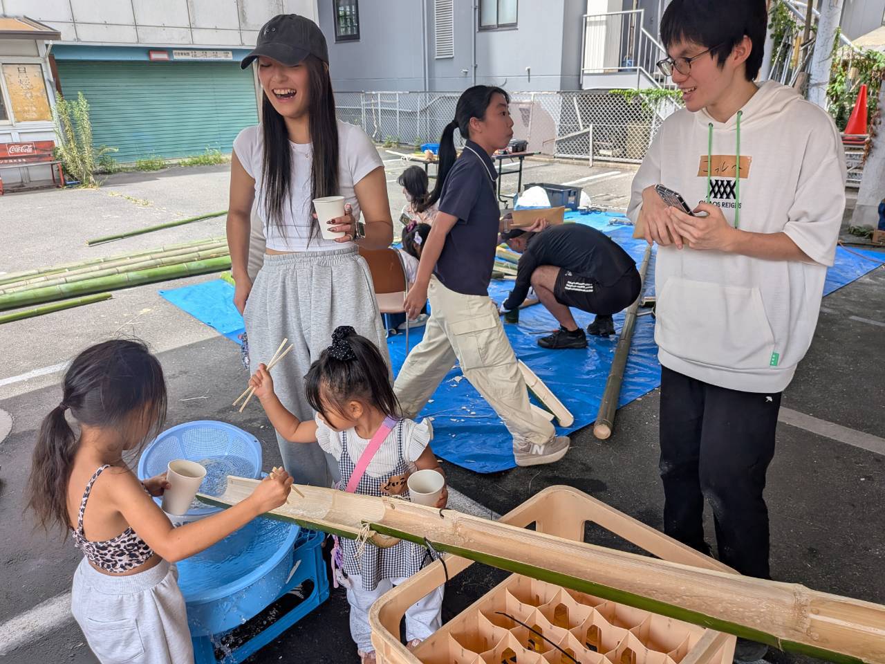 竹の流しそうめん台で盛り上がる子どもたちとスタッフ