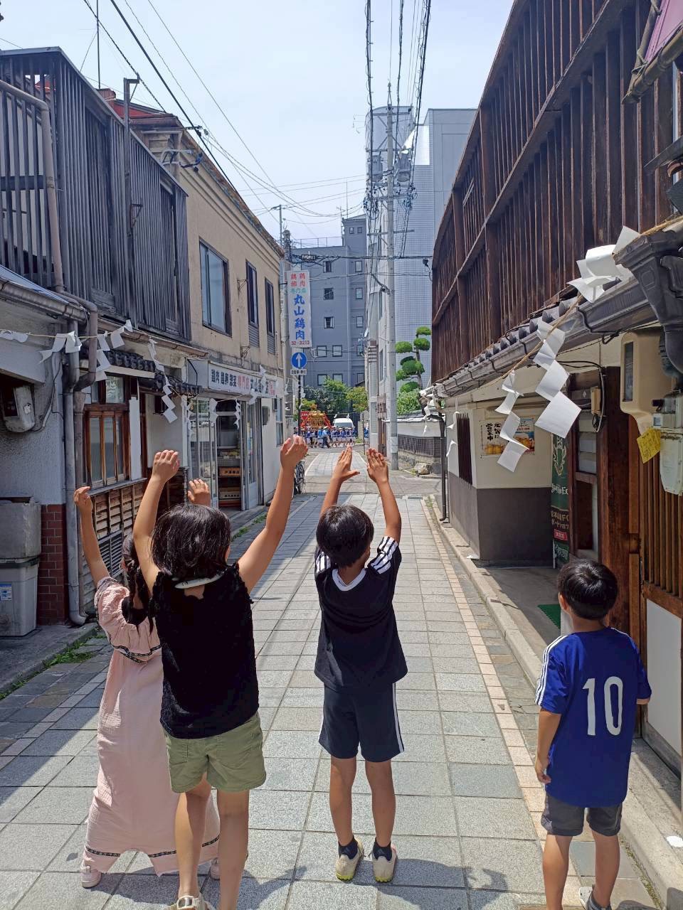 神輿を指差し、手を伸ばしてはしゃぐ子どもたち