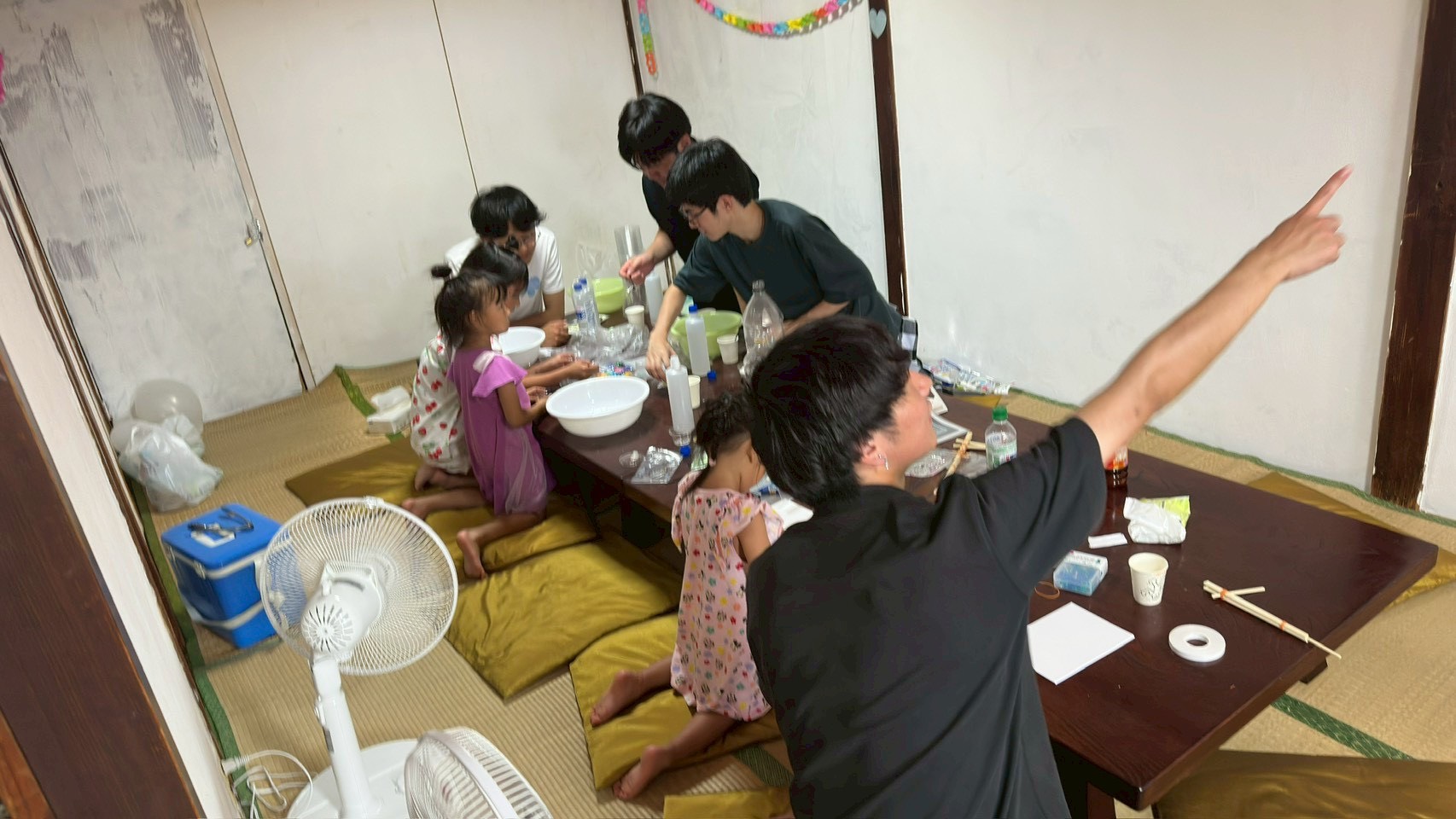 二階の座敷で、学生たちと一緒にスライムづくりを楽しむ子どもたち