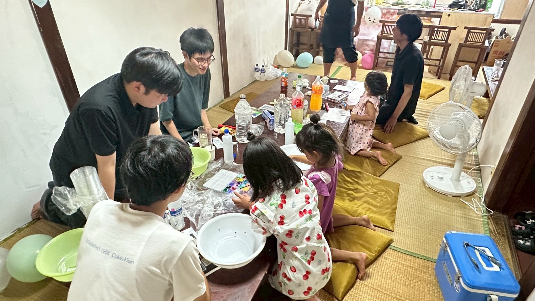 風船とスライムに囲まれ、笑顔で工作を続ける子どもたちの様子
